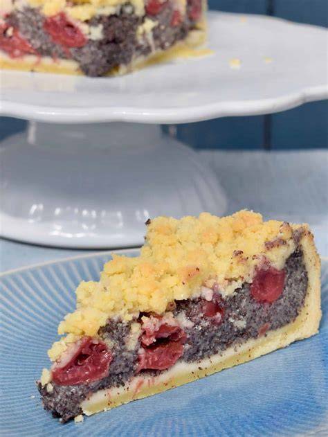 Mohn Kirsch Schmand Kuchen mit Streuseln, angeschnitten auf einer Kuchenplatte