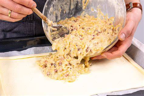 Mohn-Pudding-Masse wird auf Blätterteig glatt gestrichen