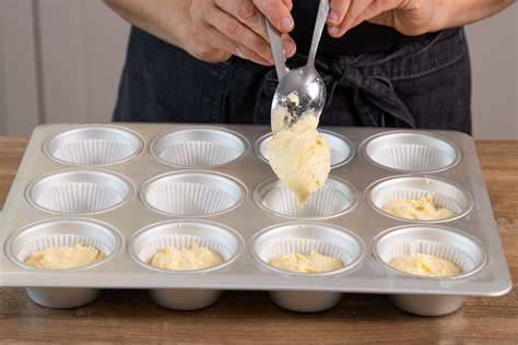 Muffinblech gefüllt, Eisportionierer teilt Teig gleichmäßig