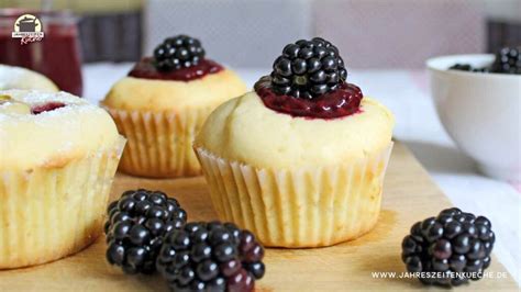 Muffins mit Pudding Füllung und Beeren auf einem Holztisch angerichtet