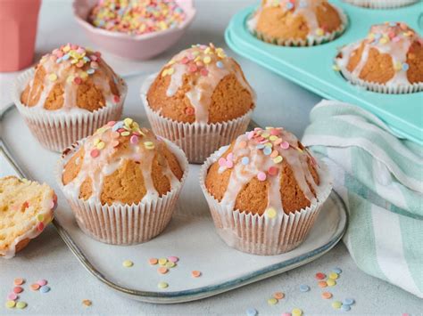 Muffins mit buntem Konfetti im Teig und Zuckerguss