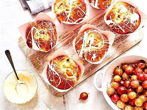 Muffins mit weißer Schokolade und frischen Stachelbeeren garniert
