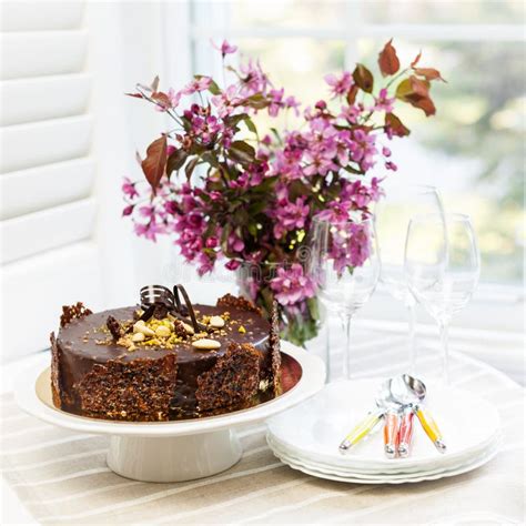 Muttertagsblumen und Schokoladenkuchen auf dem Tisch