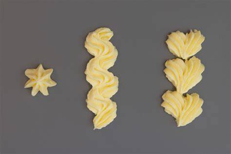 Nahaufnahme: Pastell-Mähne mit Sterntülle gespritzt, Zuckeraugen und Goldhorn