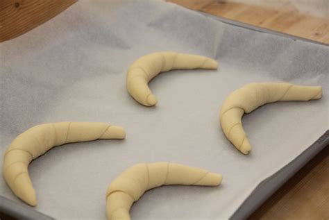 Nahaufnahme Teigkugeln und geformte Kipferl auf Backblech