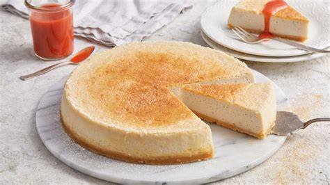 New York Cheesecake mit Schmand Topping auf weißem Teller