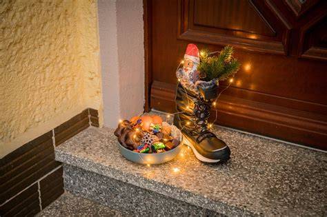 Nikolausstiefel vor der Tür mit Schokolade und Mandarinen