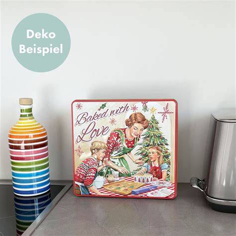 Nostalgische Blechdose mit Weihnachtsmotiv neben einem Teller Mandelplätzchen