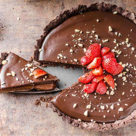 Nutella Glas, angeschnittene Torte mit Nutella-Füllung, Haselnüsse und Kakao