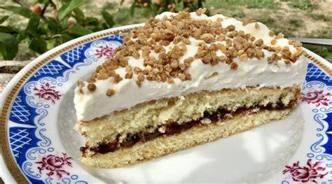 Nutellakuchen auf einer Tortenplatte, dekoriert mit Streuseln und Haselnusskrokant