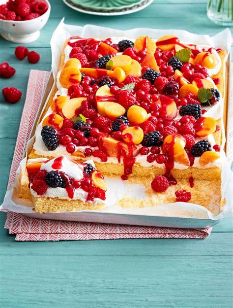 Obstkuchen mit saisonalen Früchten und Cupcakes mit cremigem Topping