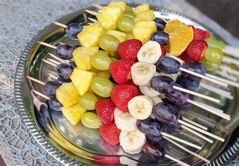 Obstvariationen: Bananen, Erdbeeren, Trauben, Ananas auf Holzspieß