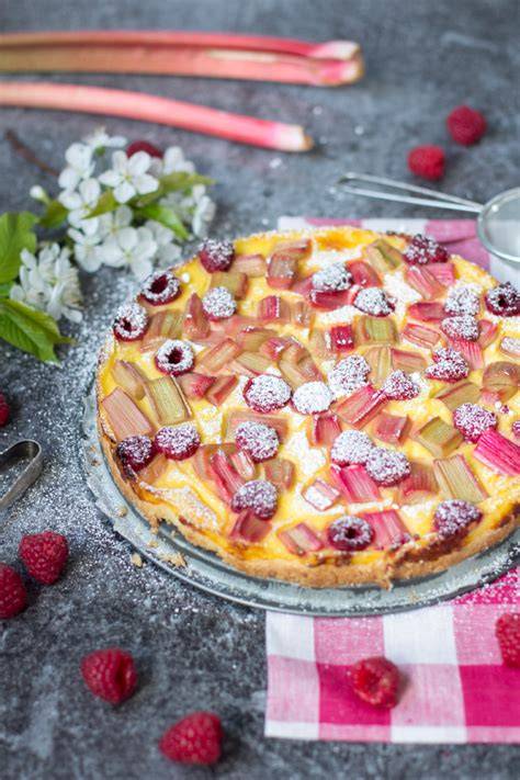 Ofenfeste Form mit rohem Teig, Rhabarber und Himbeeren