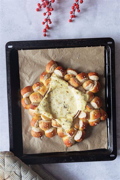 Ofenkäse mit Hot-Honey-Glasur, Nüssen und Laugenstangen als Beilage