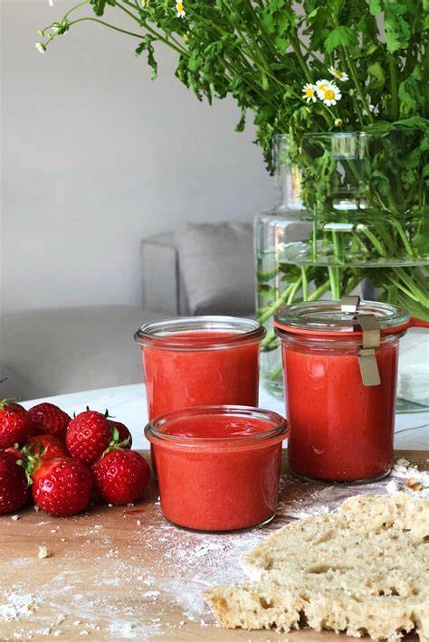 Offenes Glas Erdbeerkonfitüre mit frischen Erdbeeren und Brot