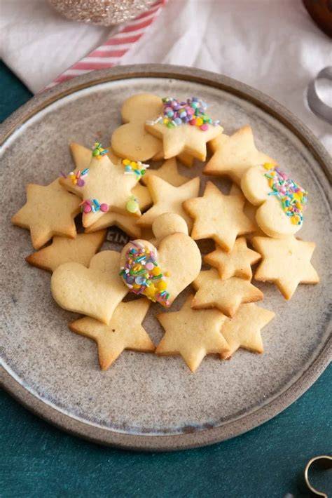 Omas Butterplätzchen auf einem weihnachtlichen Teller mit Ausstechformen