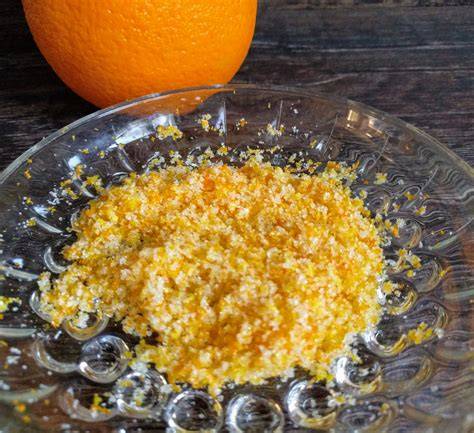 Orangen und geriebene Orangenschale auf Holzbrett