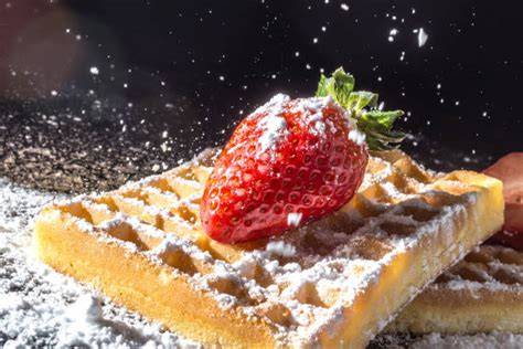 Oreo-Waffeln auf Teller mit Puderzucker und Erdbeeren