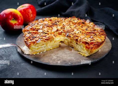 Paleo Apfelkuchen auf einem rustikalen Holzbrett, dekoriert mit Mandelblättchen