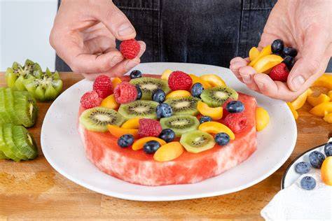 Palettenmesser verstreicht eine Quark-Sahne-Creme auf der Melonentorte