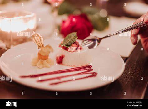 Panna Cotta mit Rosmarin auf Teller, garniert mit Fruchtkompott