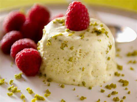 Parfait mit weißer Schokolade, Himbeeren und Pistazien im Anschnitt