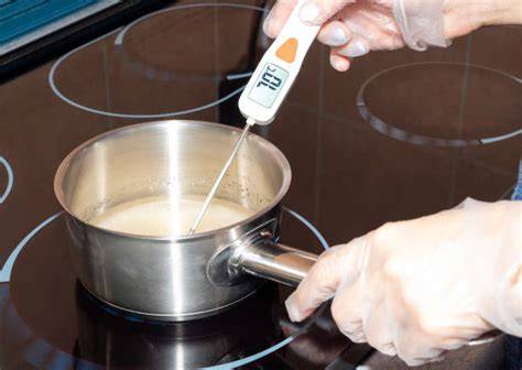 Pfanne mit Sirup, Zuckerthermometer und Eiswasser zur Probe