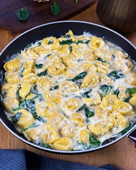 Pfanne mit Tortellini in Sahnesauce, Speck, Frühlingszwiebeln und Datteln