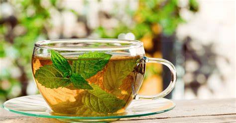 Pfefferminztee Tasse und frische Minzblätter