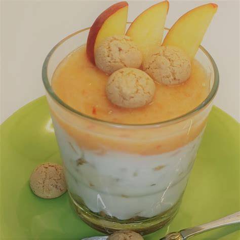 Pfirsich-Quark-Dessert, dekoriert mit Mandeln und Minzblättern