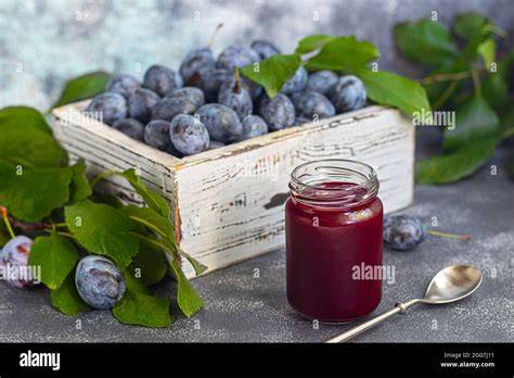 Pflaumenmarmelade im Glas auf rustikalem Tisch