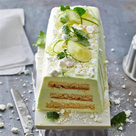 Philadelphia Limetten Torte auf rustikalem Tisch mit Minze und Limettenscheiben