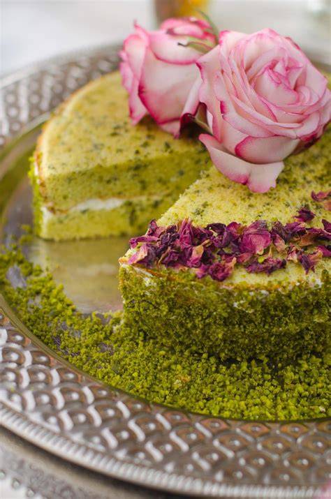 Pistazienkuchen mit Rosenwasser, dekoriert mit gehackten Pistazien und Rosenblüten