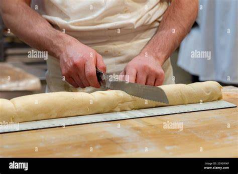 Pizzarad schneidet feine Streifen in den Teig; fertige Hörnchen auf Blech