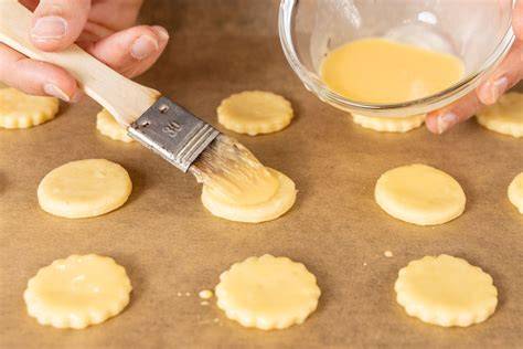 Plätzchen nach dem Bestreichen mit Eigelb und Dekor
