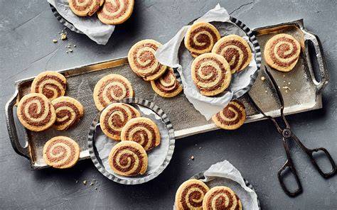 Platte mit frisch gebackenen Karamell‑Schoko‑Cookies, bestreut mit Haselnusskrokant