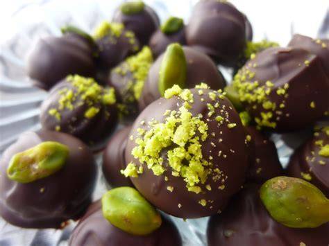 Pralinen aus Pistazien-Marzipan mit Walnuss, angerichtet auf einer Schieferplatte