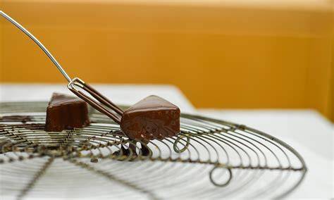 Pralinen in temperierter Kuvertüre auf Gitter