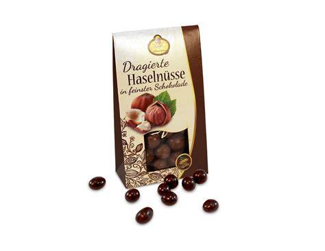 Pralinenaufschnitt mit Zutaten (Kakaomasse, Milchpulver, Haselnüsse)