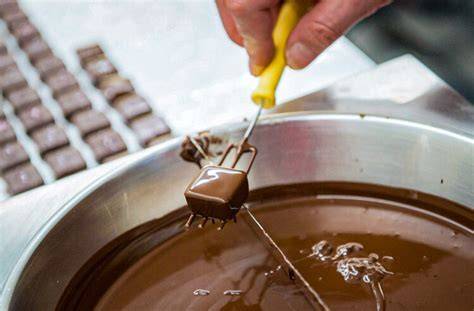 Pralinenkurs in Aktion: Teilnehmer beim Schokoladengießen