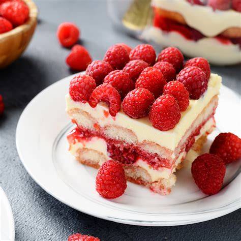 Prozessfoto: Tränken der Biskotten und Verteilen der Himbeeren auf der Creme