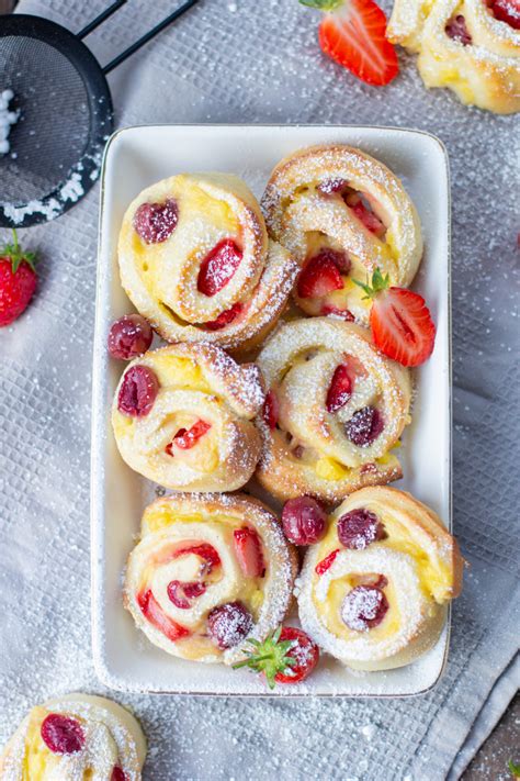 Puddingschnecken mit Puderzucker und Beeren serviert