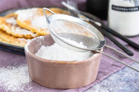 Puderzucker in Mixer und gesiebter Puder