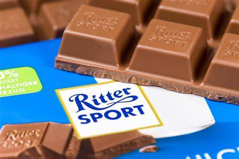 Quadratische Ritter Sport Tafel und historische Fotos der Fabrik
