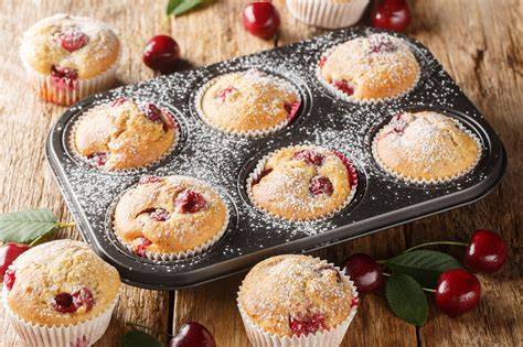 Quark‑Muffins mit Kirschen auf einem Teller