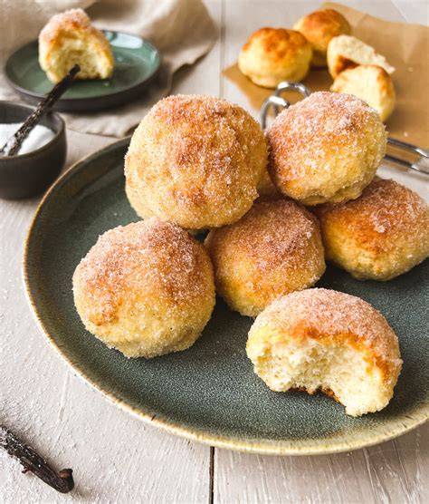 Quarkbällchen und Marmeladenschälchen auf dem gedeckten Kaffeetisch