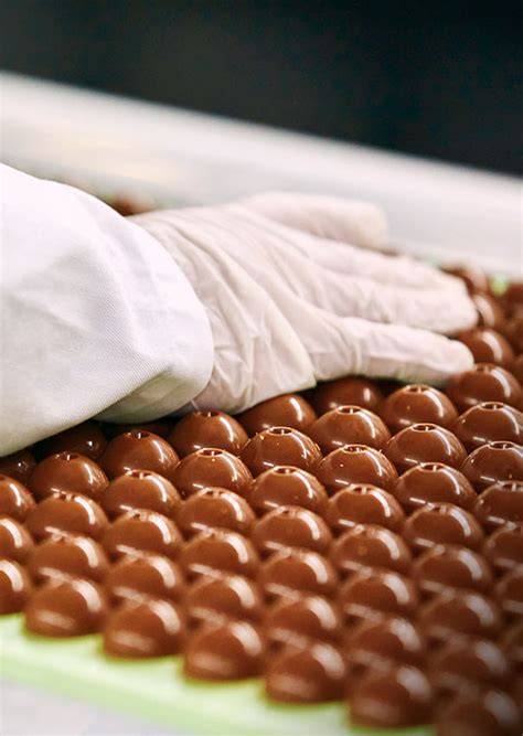 Querschnitt einer LINDOR Kugel: dünne Schokoladenhülle und zartschmelzende Füllung
