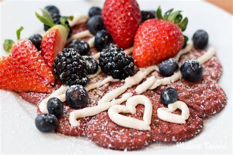Red Velvet Waffeln auf einem Servierteller mit Beeren und Vanillecreme
