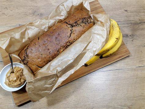 Reife Bananen und Erdnussbutter auf Holzbrett