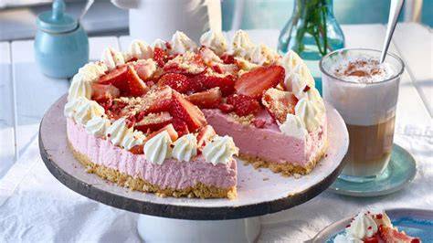 Rhabarber-Torte auf Kuchenplatte mit rosa Stielen und Sahnetupfen